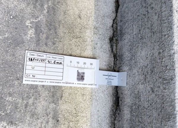 G1-Riss-Messlehre - Rissmonitor für innen und außen - mit QR-Code in einer Ecke über dem Riss montiert.